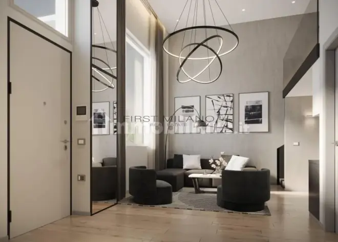 Double-height living room with a ring chandelier in a Milan apartment
